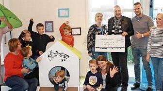 Spendenübergabe vom Lionsclub Aischgrund an den Kindergarten Mühlhausen: Kindergartenleiterin Tina Härtlein und Past-Präsident Gerhard Kress (beide mit dem Scheck) sowie Mitglieder des Elternbeirats und des Kindergartenpersonals mit Kindern Foto: Johanna Blum
