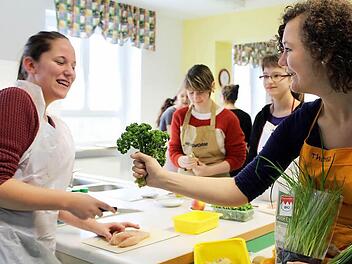 Theresa Lorey (rechts) und Anna Klossek (Stadtschwarzach) haben beim Kochen viel Spaß. Im Hintergrund bereiten Lena König (Bergtheim) und Jana Emmert (Kleinlangheim) schon das Menü vor. Foto: Pfannes