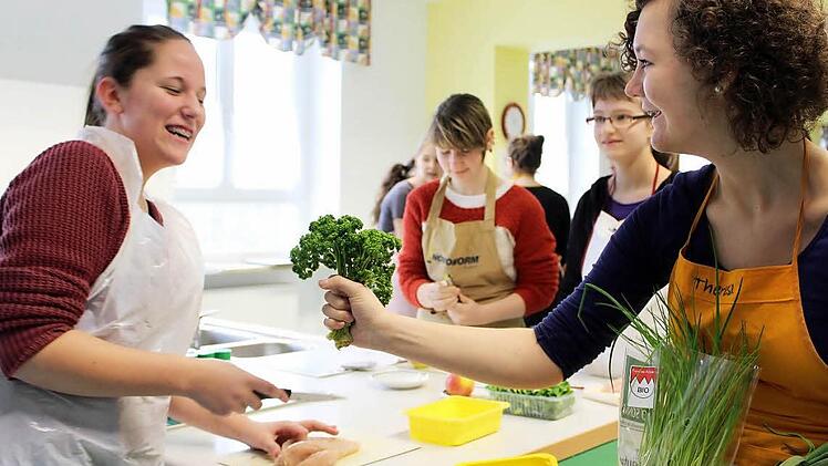 Theresa Lorey (rechts) und Anna Klossek (Stadtschwarzach) haben beim Kochen viel Spaß. Im Hintergrund bereiten Lena König (Bergtheim) und Jana Emmert (Kleinlangheim) schon das Menü vor. Foto: Pfannes