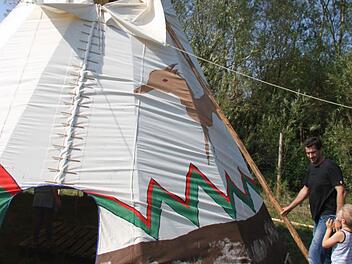 Ein ganzes Wochenende waren die Zehntklässler der Waldorfschule damit beschäftigt, ein Indianer-Tipi zu bauen. Adrian Göldner und Tizian zeigen, wie die Rauchklappen funktionieren. Foto: Sonja Adam