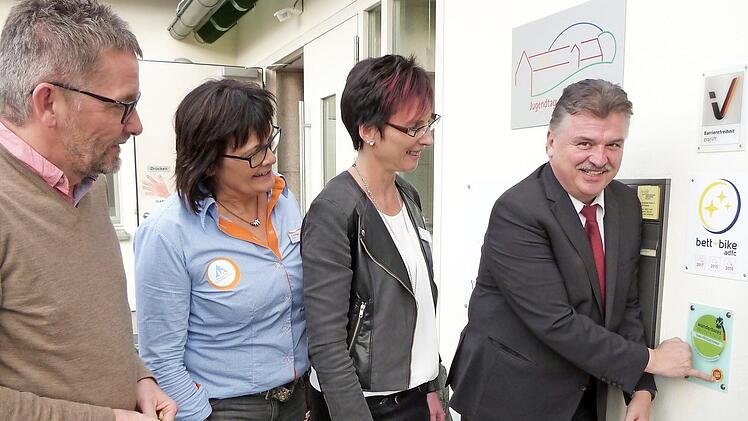 Landrat Klaus Peter Söllner bringt eigenhändig die erneute Zertifizierung zum "Qualitätsgastgeber Wanderbares Deutschland" am Eingang zur Jugendherberge an. Weiter nach links Bettina Schütz, Hildegard Eichmann und Jürgen Ziegler. Foto: Werner Reißaus