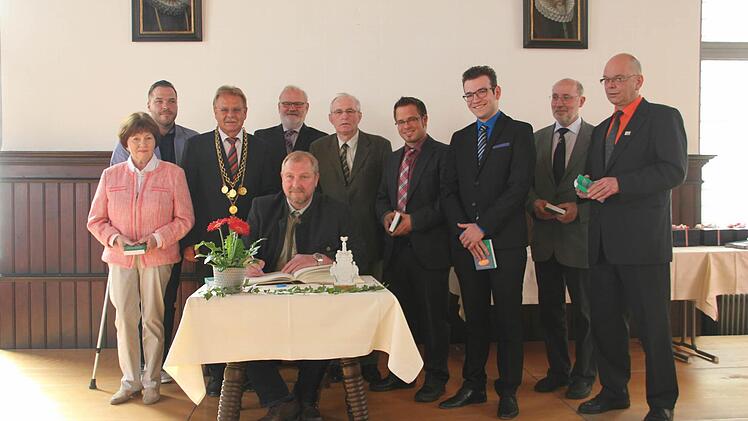 Die neuen Stadtratsmitglieder tragen sich ins Goldene Buch ein.