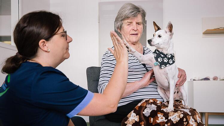 Gib mir fünf: Zum Abschluss der Gruppensitzung zeigt Therapiebegleithündin Meiga ihrer Besitzerin Marina Pompe (links) und der 84 Jahre alten Teilnehmerin Anni Mäder, auf welche Befehle sie gehorcht. Foto: Marian Hamacher