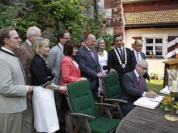 Unter vielen gewogenen Blicken trägt sich der CSU-Ehrenvorsitzende Theo Waigel ins Gästebuch der Gemeinde Egloffstein ein. Fotos: Löwisch