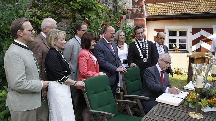 Unter vielen gewogenen Blicken trägt sich der CSU-Ehrenvorsitzende Theo Waigel ins Gästebuch der Gemeinde Egloffstein ein. Fotos: Löwisch