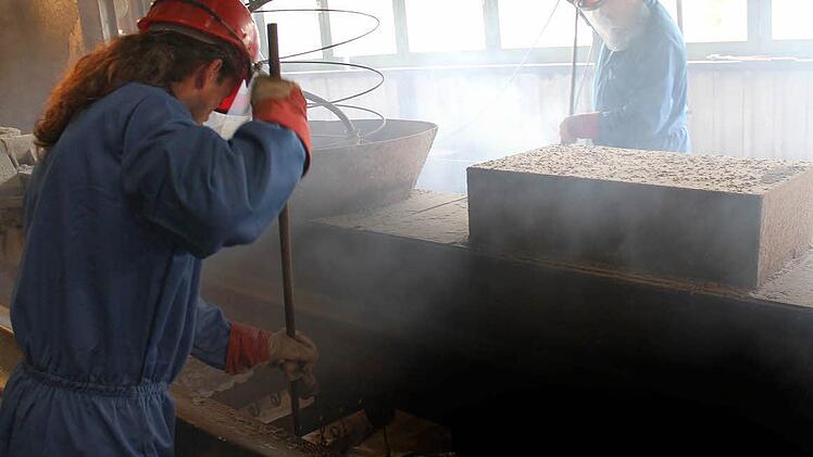 Ein schweißtreibender Job: 450 Grad hat das Zink in dem Becken vor den Arbeitern. Foto: Martin Kreklau