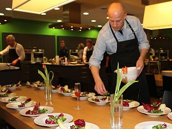 Michael Straub kreiert seine Salat-Vorspeise - anschließend wird der Salat mit der Apfel-Ziegenkäse-Kreation, mit gerösteten Pinienkernen und den Granatapfelkernen verziert. Fotos: Sonja Adam