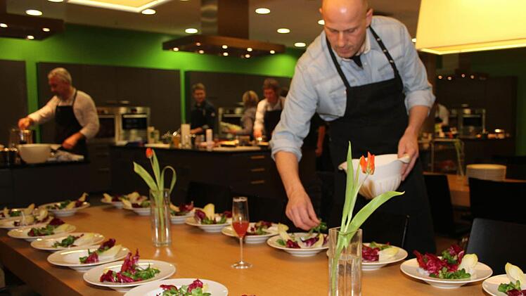 Michael Straub kreiert seine Salat-Vorspeise - anschließend wird der Salat mit der Apfel-Ziegenkäse-Kreation, mit gerösteten Pinienkernen und den Granatapfelkernen verziert. Fotos: Sonja Adam