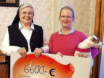 Ursula Fr&ouml;hlich (r.) &uuml;bergab den symbolischen Spendenscheck an Schwester Ruth Rei&szlig;ig. Foto: Manfred Welker