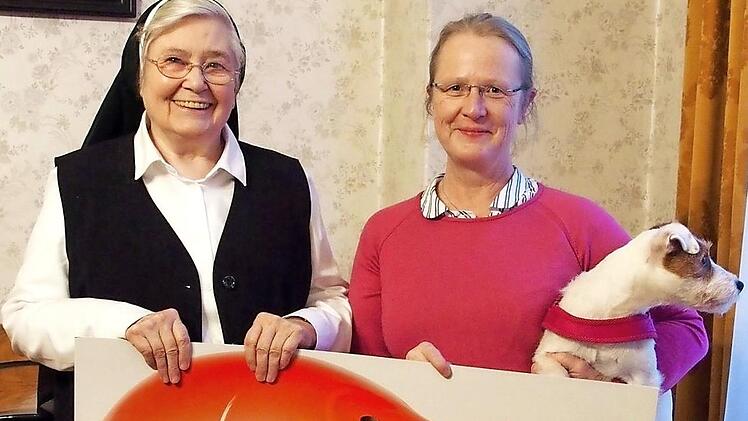 Ursula Fr&ouml;hlich (r.) &uuml;bergab den symbolischen Spendenscheck an Schwester Ruth Rei&szlig;ig. Foto: Manfred Welker