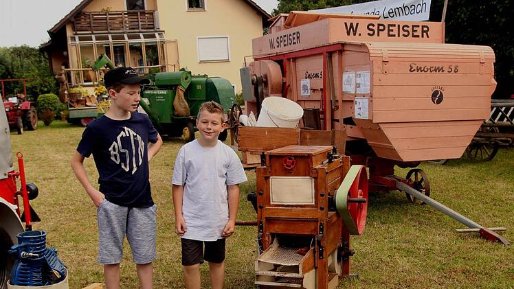 Die beiden Buben staunten über die Maisschäl- und Riffelmaschine vor der alten Dreschmaschine.