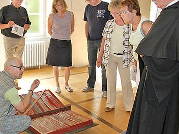 Künstler Thomas Pfarr erläutert den Besuchern gern, wie sein "Buch der Offenbarung" entstanden ist und was es erzählt.  Foto: Martina Straub