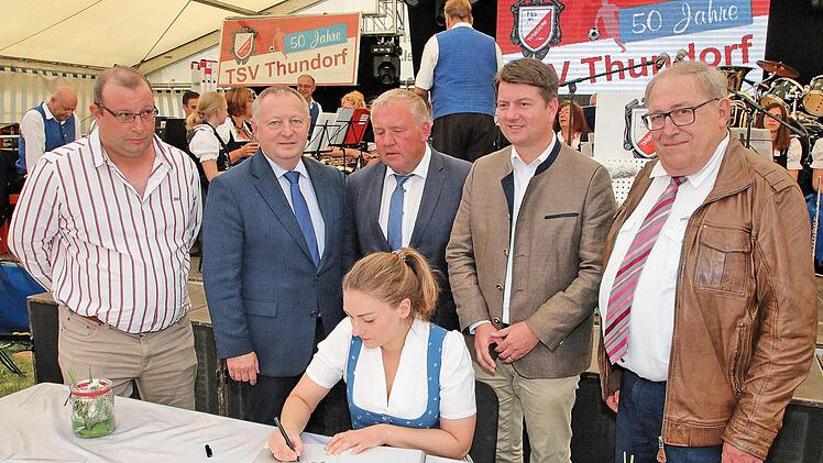 Ins Goldene Buch der Gemeinde Thundorf trug sich Staatsministerin Judith Gerlach ein. Hinter ihr (von links) der Vorsitzende des TSV Thundorf, Dieter Büchner, Landrat Thomas Bold, Bürgermeister Egon Klöffel, MdL Sandro Kirchner und der TSV-Ehrenvorsitzende Philipp Bauernschubert. Foto: Dieter Britz