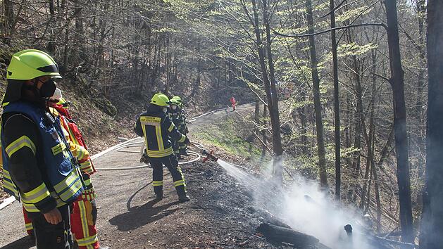 Nachdem sie den Brand unterhalb der Burgruine Nordeck gelöscht hatten, mussten die Feuerwehrleute den Waldboden noch längere Zeit wässern, um ein mögliches Aufglimmen von Glutnestern zu verhindern.