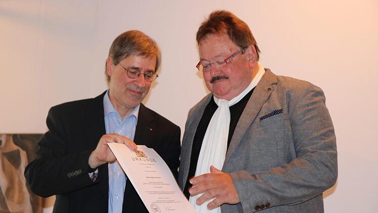 Klemens Brosig von der Regierung von Oberfranken überreicht Jürgen Vonbrunn die Abschiedsurkunde.