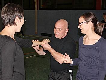 Harald Rögner Mitte, zeigt zwei Teilnehmerinnen Abwehrtechniken, mit denen man sich wirkungsvoll gegen Angriffe wehren kann.  Foto: Helmut Will