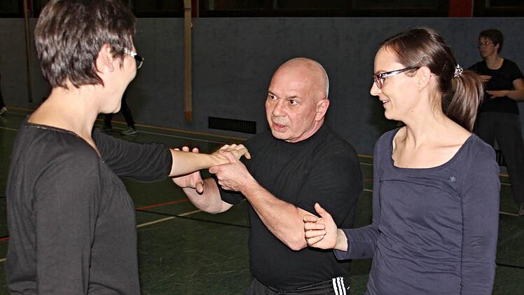 Harald Rögner Mitte, zeigt zwei Teilnehmerinnen Abwehrtechniken, mit denen man sich wirkungsvoll gegen Angriffe wehren kann.  Foto: Helmut Will
