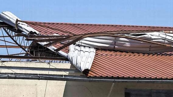 Auf einer Lagerhalle in der Zeiler Straße in Haßfurt hat der Sturm ein Blechdach regelrecht aufgerollt. Ein weiterer Teil des Daches wurde heruntergerissen und landete auf einem Nachbargrundstück.  Foto: René Ruprecht