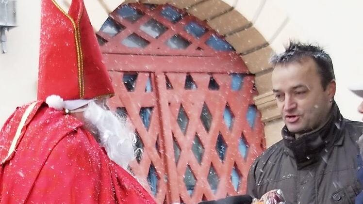 Im dichten Schneetreiben leuchtete der rote Mantel des Nikolaus' heraus, der Geschenke verteilte.