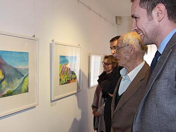 Bürgermeister Martin Bernreuther lässt sich von Heinz Schnauder durch die Ausstellung führen. Im Hintergrund sind Sohn Axel Schnauder und die Patentochter der Künstlerin Sabine Zühlke zu sehen. Foto: Katharina Müller-Sanke