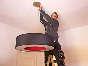 Versteht sein Handwerk: Till Rosenbusch montiert eine Lampe an der Decke eines Gebäudes in der Seifartshofstraße in Coburg. Foto: Sven Dörr