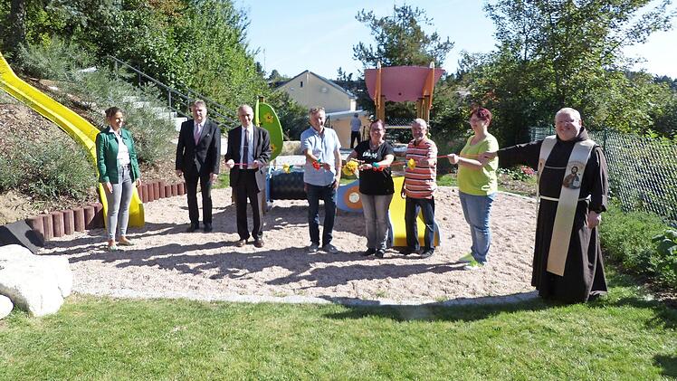 Mit dem Durchschneiden eines Bandes gab Kindergartenleiterin Michaela Stark (Vierte von rechts) den neuen Spielplatz des Kindergartens "Arche Noah" frei. Mit im Bild (von links) Architektin Susanne Augsten, Landrat Klaus Peter Söllner, Bürgermeister Franz Uome, Georg Schramm und Hans-Günther Löffler von der Kirchenstiftung, Elternbeirätin Larissa Völtel und Pfarrer Pater Adrian Manderla Foto: Klaus Peter Wulf