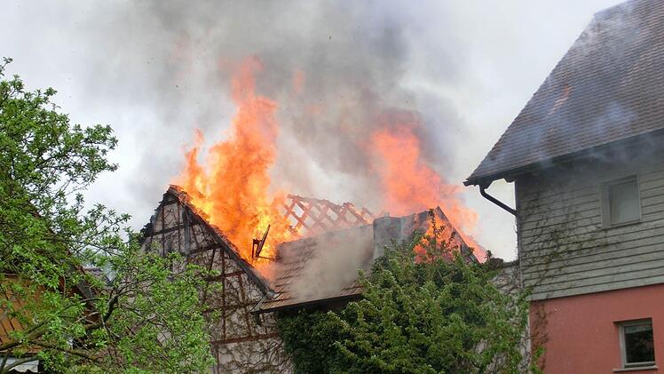 An einer Scheune in der Wülfershausener Straße in Langendorf, direkt neben der örtlichen Schule, geriet am Sonntagnachmittag der Dachstuhl in Brand. Die umliegenden Feuerwehren versuchen ein Übergreifen der Flammen auf Wohnhäuser zu verhindern. Foto: Peter Rauch