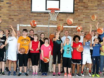 Basketbälle im Flugmodus: Die Kinder der Bertold-Scharfenberg-Schule und alle beteiligten Projektpartner mit Oberbürgermeister Andreas Starke und Schulleiterin Brigitte Cleary an der Spitze beim Auftakt des Inklusionsprojekts von Brose Bamberg "Basketball verbindet" in der Halle des Dientzenhofer-Gymnasiums  Foto: Bertram Wagner