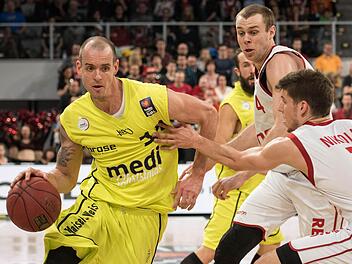 Bayreuths Steve Wachalski (l) kämpft mit Bambergs Aleksej Nikolic (r) und Nicolo Melli (2.v.r.) um den Ball. Foto: Nicolas Armer/dpa