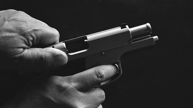 Der Täter soll sein Opfer mit einer Schusswaffe bedroht haben. Anschließend durchsuchte er die Räumlichkeiten nach Bargeld. Symbolfoto: pixabay/5191107