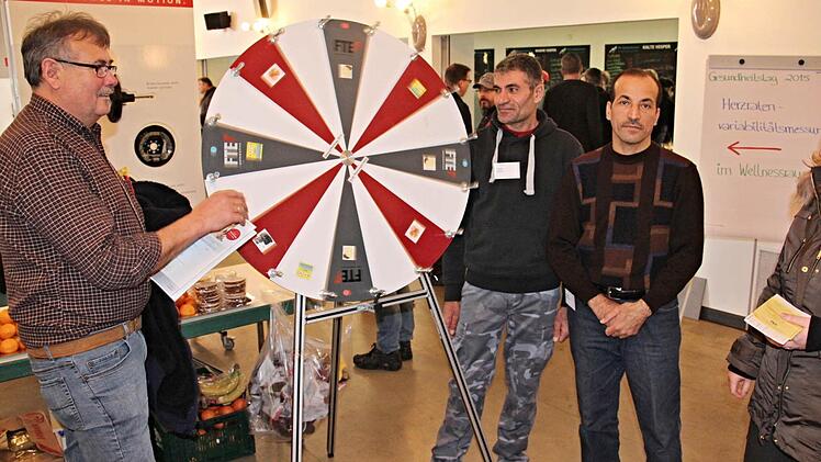 Helmut Schmalz aus Neubrunn (links) am Glücksrad. Osama Abdallah und Azad Omar (von rechts) überwachen die Aktion und verteilten kleine Preise. Foto: Helmut Will