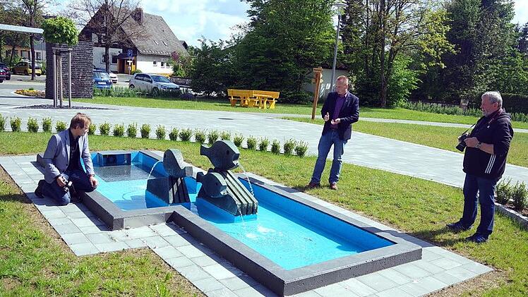 Die Wasserscheide symbolisiert der Brunnen von Alfred Russ. Im Bild Bürgermeister Thomas Löffler (Mitte) mit den Kreisheimatpflegern Robert Wachter (links) und Siegfried Scheidig.