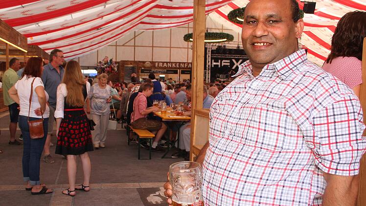 Latif aus Pakistan verkauft Rosen und blinkende Hüte auf der Bierwoche - oder er feiert mit.