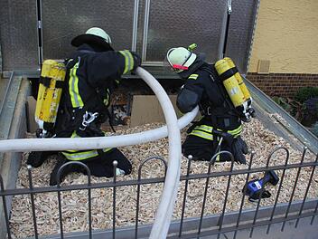 Feuerwehrleute spritzen in Friesen Löschschaum in den Hackschnitzelbunker. Foto: Schedel