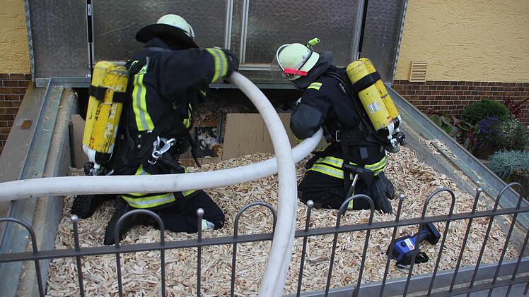 Feuerwehrleute spritzen in Friesen Löschschaum in den Hackschnitzelbunker. Foto: Schedel