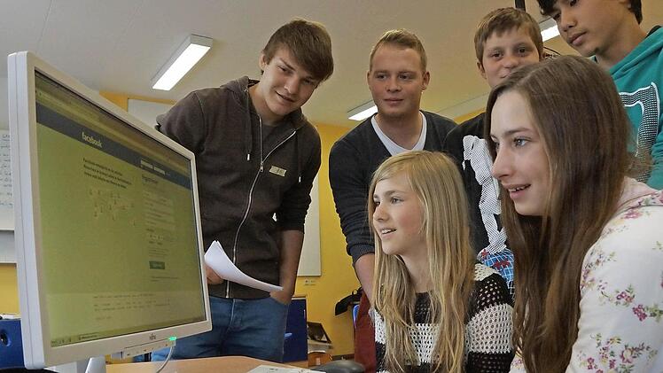Jan Zentgraf und Sebastian Kusche (hinten von links) erklären Siebtklässlern den richtigen Umgang mit Facebook. Foto: Arkadius Guzy