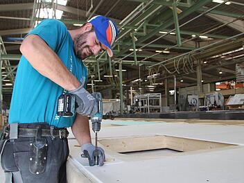 Hier entsteht ein Fertighaus: Vincenzo Portarulo arbeitet in der Fertigungshalle von Hanse Haus in Oberleichtersbach. Foto: Ulrike Müller