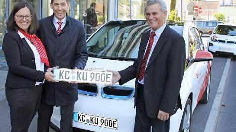 Landrat Oswald Marr (rechts) übergab das erste E-Kennzeichen an Barbara Haslinger und Steffen Potstada von der Sparkasse. Im Hintergrund der Kulmbacher "Bruder" des Kronacher E-Autos.  Foto: Friedwald Schedel