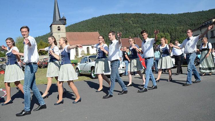 Froh gelaunt ziehen die Zechpaare der KWG im Festzug vorbei an der Dreieinigkeitskirche und den Oldtimern (im Hintergrund).  Foto: Karl-Heinz Hofmann