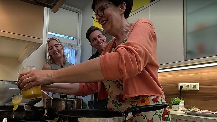 Renate und Pascal beobachten Petra beim Kochen.