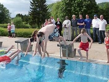 Den Startschuss zum Anschwimmen gab Technischer Leiter Florian Krepinsky (rechts). Bürgermeister Roland Wolfrum springt vom Startblock 6 ins Wasser. Foto: Werner Reißaus