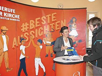 Jacqueline Stößel mit einem Interessierten am Stand der Diözesanstelle Berufe der Kirche. Foto: Marion Krüger-Hundrup