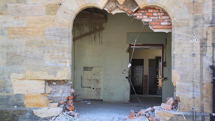 In dieses zuvor mit Ziegelsteinen vermauerte Portal hat der Bagger schon eine Schneise gebrochen, damit die Entkernungsarbeiten an dem Sandsteinquaderbau beginnen konnten.
