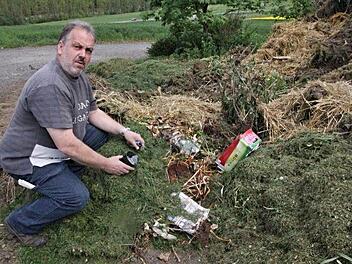 Harald Grell, der die Grünschnittdeponie am Lindenhof für den Abfallwirtschaftsbetrieb des Landkreis Haßberge betreibt, entfernt Plastik und sonstige Gegenstände, die auf dem Grünschnitt nichts zu suchen haben. Foto: Helmut Will