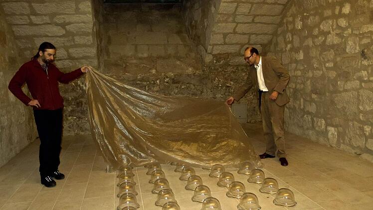 Kurator Sven Hauschke (rechts) und Restaurator Heiner Grieb zeigen Sebastian Richters Installation "Grandpa's Holiday"