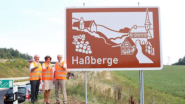 Rh&ouml;n-Grabfelds Landrat Thomas Habermann, Gesch&auml;ftsf&uuml;hrerin Ha&szlig;berge Tourismus Susanne Volkheimer und Ha&szlig;berge-Landrat Wilhelm Schneider pr&auml;sentierten die touristischen Unterrichtungstafeln  bei Ma&szlig;bach. Foto: Ina Heupt