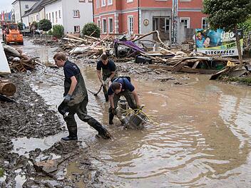 Mitarbeiter des Technischen Hilfswerks (THW) saugen am 3. Juni in der Innenstadt von Simbach am Inn Wasser von der Straße. Die Flutwelle in Niederbayern hat sieben Todesopfer gefordert. Foto: Peter Kneffel/dpa