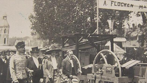 Juni 1910 in Coburg: Andras Flocken (mit Zylinder) führt Herzog Carl-Eduard von Sachsen-Coburg und Gotha (links) sowie dessen Gemahlin Herzogin Viktoria Adelheid zu seinem Stand an der landwirtschaftlichen Ausstellung am Anger.
