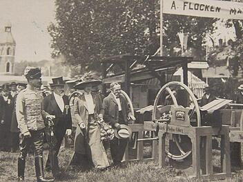 Juni 1910 in Coburg: Andras Flocken (mit Zylinder) führt Herzog Carl-Eduard von Sachsen-Coburg und Gotha (links) sowie dessen Gemahlin Herzogin Viktoria Adelheid zu seinem Stand an der landwirtschaftlichen Ausstellung am Anger.