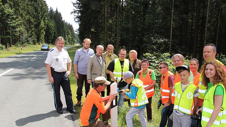Gemeinsam wurden 180 Wildwarnreflektoren an Leitpfosten entlang der Kreisstraße 5 zwischen Buchbach und Rothenkirchen auf 3,5 Kilometern Länge angebracht. Hier montieren der Rothenkirchner Revierleiter Alexander Kelle und Jannick Löwe vom Verein "Schau hin" einen Reflektor.